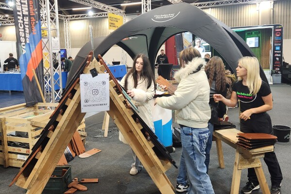 Schülerinnen an einem Stand für Dachdecker