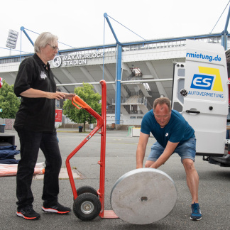 ( Bild: Christine Dierenbach / Christine Dierenbach/Amt fuer Kommunikation und Stadtmarketing ) … beim Transport und dem Aufstellen der schweren Schirmständer …
