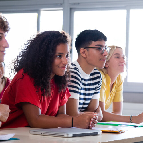 Black female high school student in class with multiracial classmates. African american college student in class with multiethnic friends. Education concept.