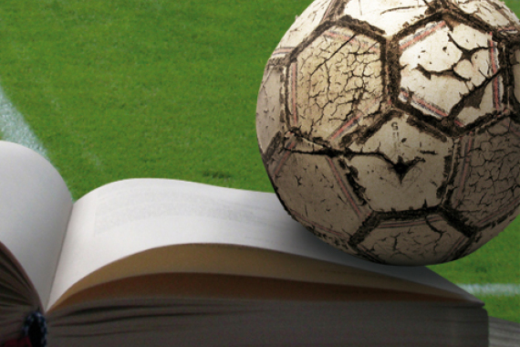 Ein Fußball liegt auf einem offenen Buch.