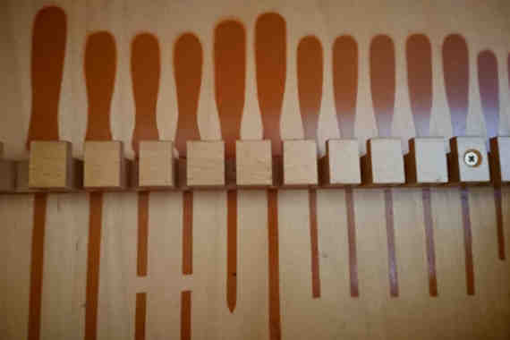 Wand mit Halterungen für Schraubenzieher, markiert mit Bildern der passenden Werkzeuge