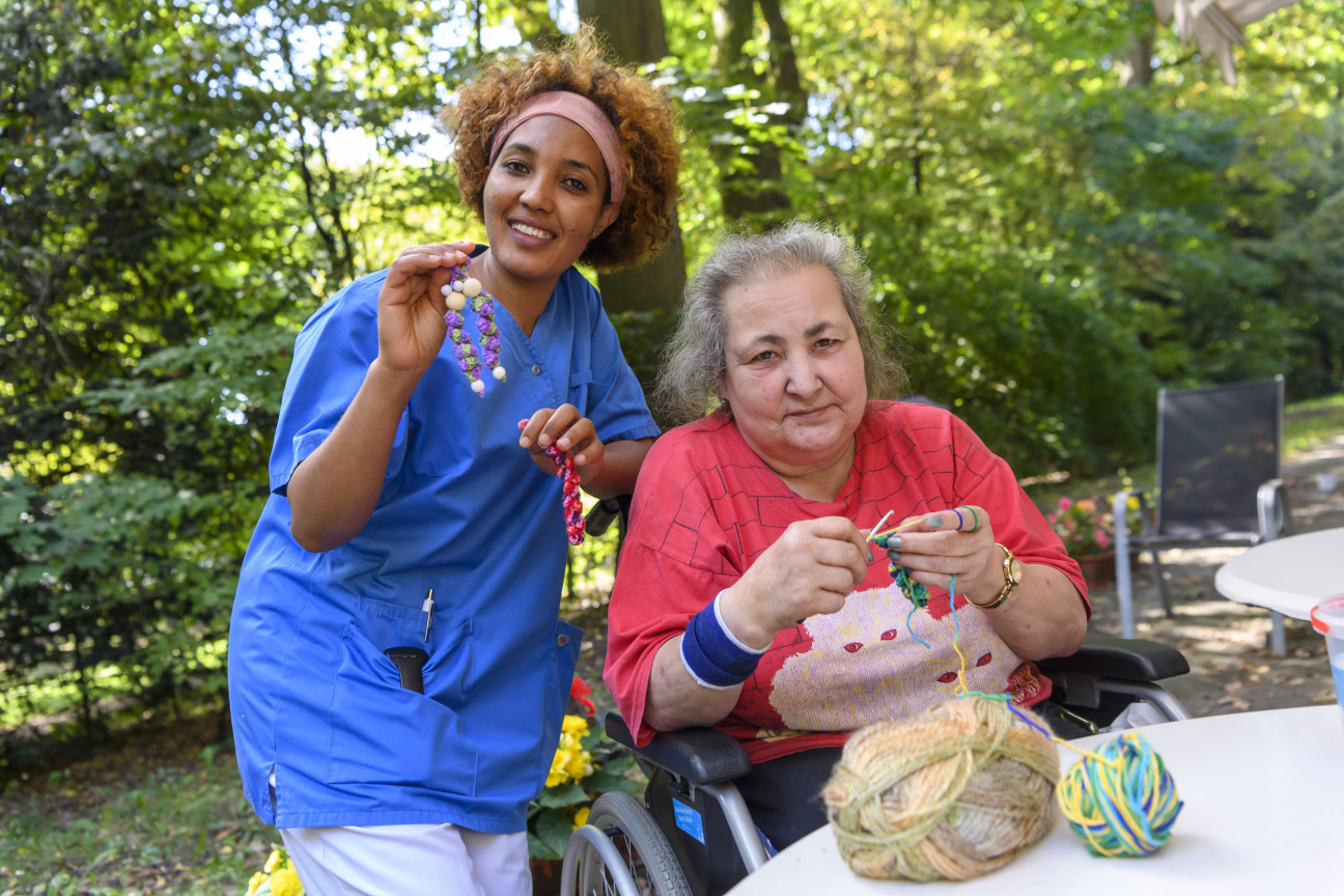 Bewohnerin strickt mit Mitarbeiterin