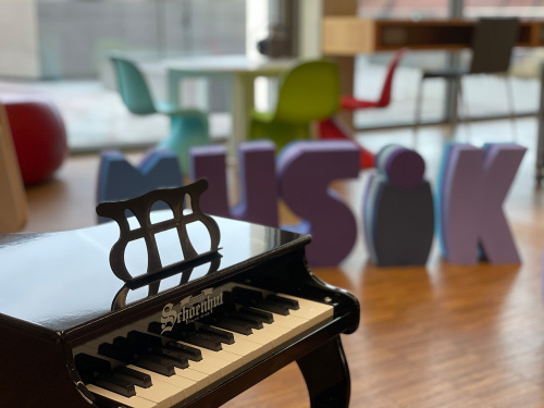 Piano mit MUSIK Buchstaben im Hintergrun