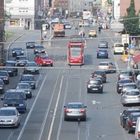 Die Fotoaufnahme zeigt einen exemplarischen Ausschnitt aus einem großstädtischen Straßenraum mit verschiedenen Quellen für Verkehrslärm (Straße und Schiene)