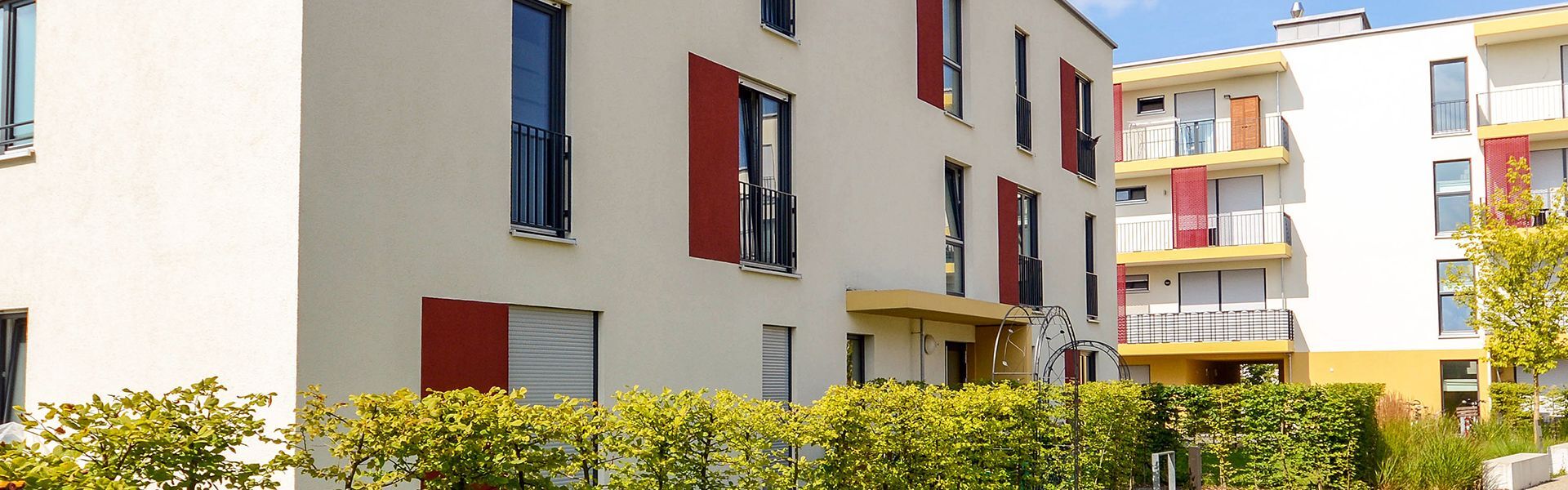 Häuserblock mit Büschen und Gehweg