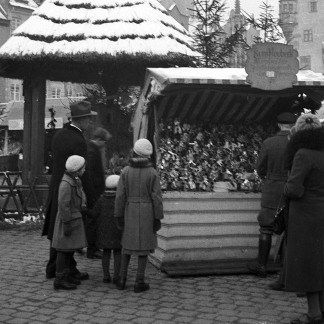 ( Bild: Stadtarchiv A39 I 32 D / Stadtarchiv A39 I 32 D / Stadt Nürnberg ) 1935: Besucher vor einer Bude mit Zwetschgenmännle.