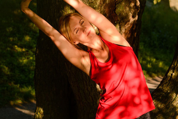 Eine Frau macht Dehnungsübungen in der Natur.