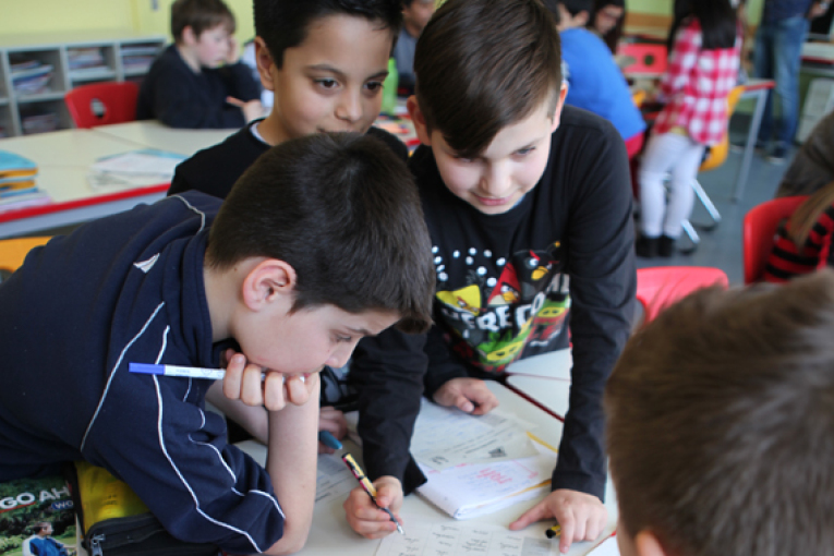 Drei Kinder trainieren, üben und vertiefen gemeinsam ihre Aufgaben im Unterricht.