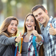 Three happy students looking at you with thumbs up in an university campus