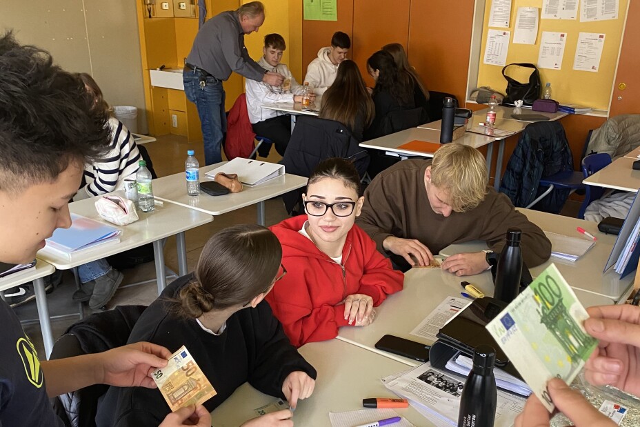 Schülerinnen und Schüler mit Falschgeld während dem Vortrag der Deutschen Bundesbank, Bild © Berufliche Schule 4 / Stadt Nürnberg