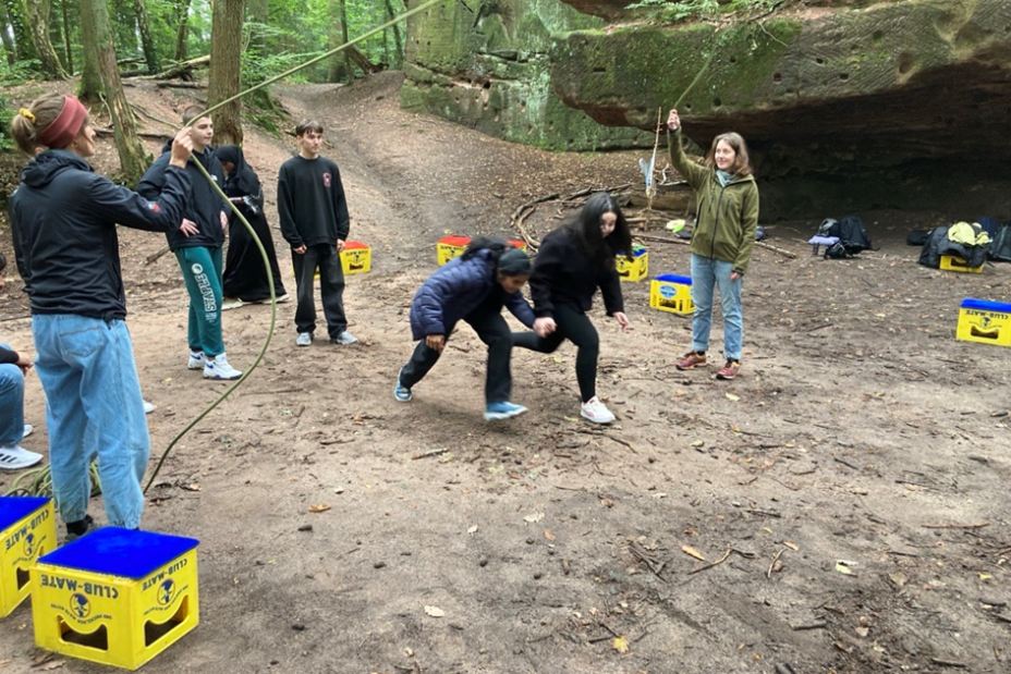 Ein Schülerpaar rennt geduckt unter einem schwingenden Sprungseil hindurch, Bild © Berufliche Schule 4 / Stadt Nürnberg