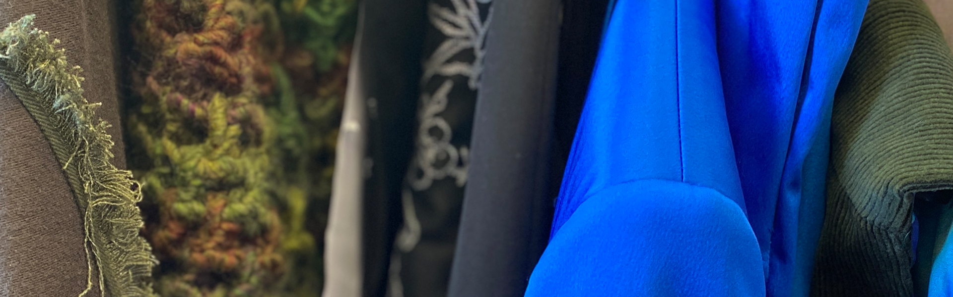 Kleidung verschiedene Oberteile auf Bügeln