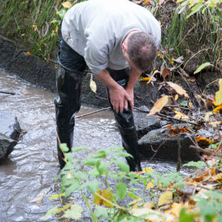 ( Bild: Christine Dierenbach / Stadt Nürnberg ) Im Ablauf reinigt er Gummistiefel, Arme und Hände vom Schlamm.