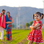 Indian farmer with wife and daughter at agriculture field.