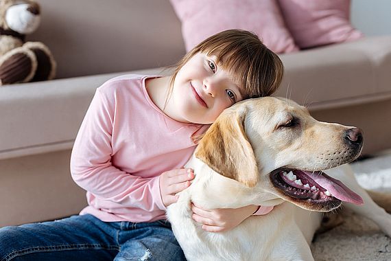 Child with down syndrome cuddling with dog