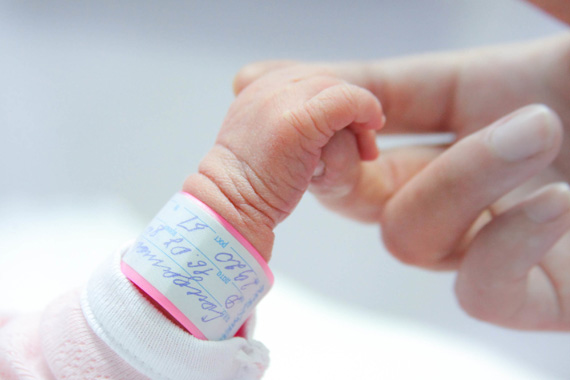Hand eines Neugeborenen wird gehalten