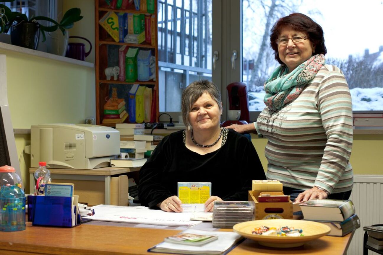 Zwei Frauen hinter einem Schreibtisch lächeln in die Kamera, Bild © Andrea Will / Stadt Nürnberg