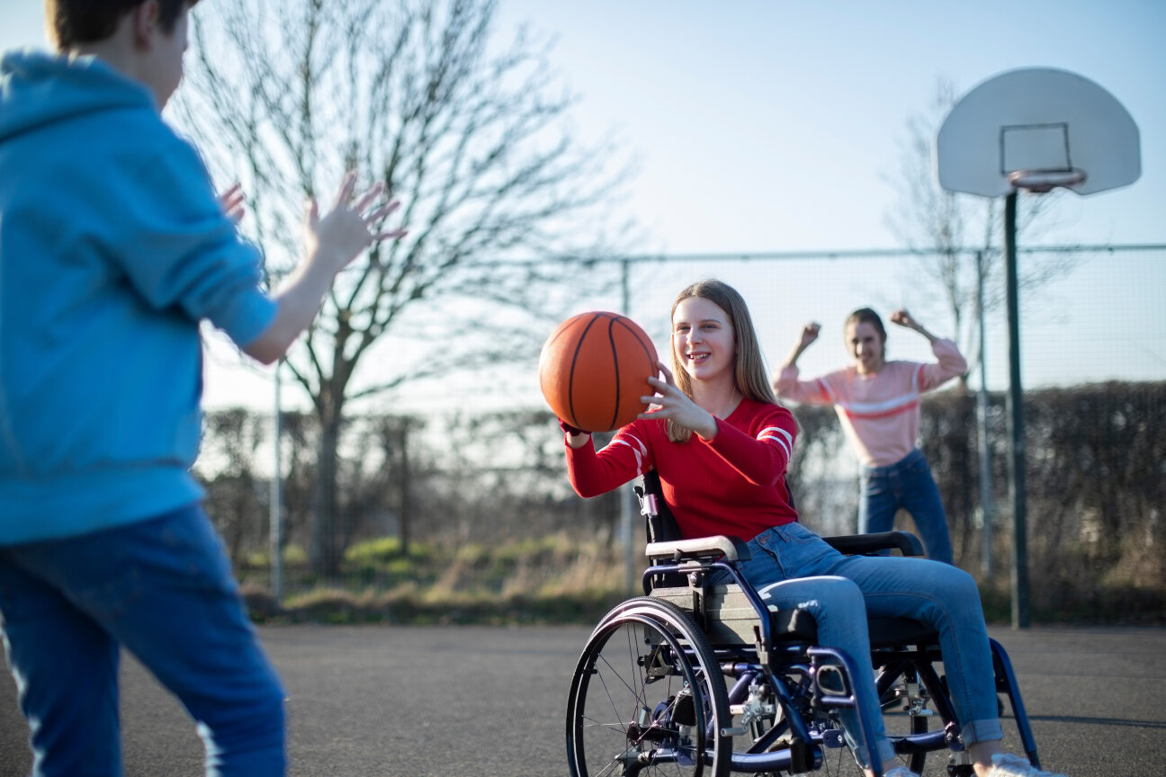 Teenage Girl In Wheelchair Playing Basketball With Friends, Bild © ©Daisy Daisy - stock.adobe.com