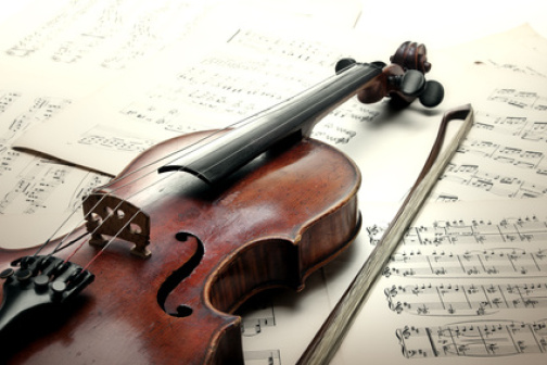 Old scratched violin with sheet music. Vintage style.