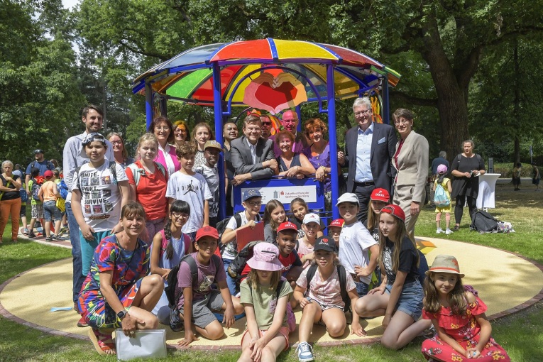 Gruppenfoto von Kindern mit Oberbürgermeister Marcus König und weiteren unter dem Pavillion der 10. Station der Straße der Kinderrechte