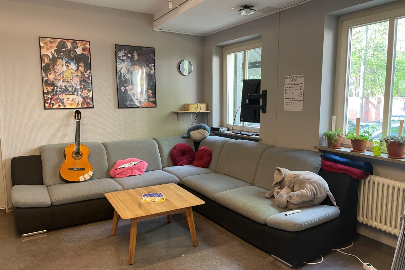 Großes graues Sofa mit Plüschtieren darauf. Eine Gitarre lehnt in der Ecke. An der Wand hängen zwei Poster mit Anime-Motiven., Bild © Jugendtreff MAX