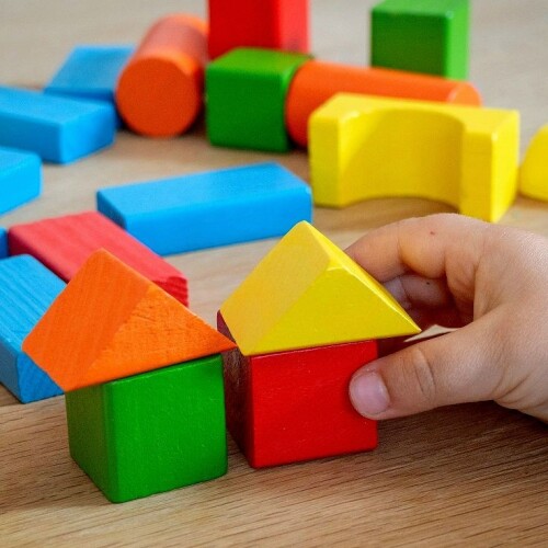 Kinderhand spielt mit bunten Holzklötzen © unsplash.com