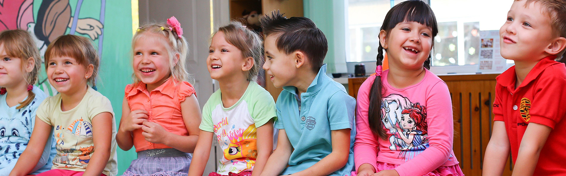 Mehrere lachende Kinder auf einer Bank