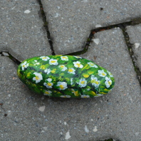 grüner Stein mit weißen Blumen