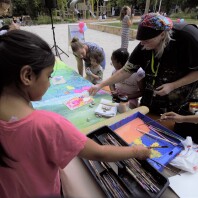 Kinder malen mit einer Künstlerin auf dem Tisch