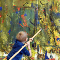 Kind beim Malen auf der Leinwand