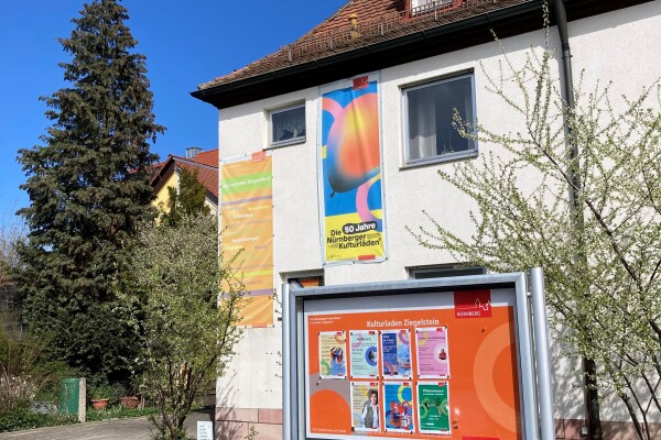 Haus mit Plakaten und Schaukasten davor