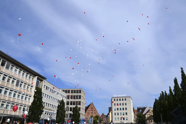 Rote und weiße Luftballons steigen über dem Konmarkt in den Himmel auf.