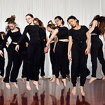 Die schwarz gekleideten Tänzerinnen des Jugendtanzensembles springen alle gleichzeitig in die Luft