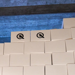 Viele bis zur Decke gestapelte, weiße Kartons. Zwei davon tragen das Quelle-Logo.