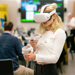 Eine junge Frau trägt ein VR Headset in einem Klassenzimmer