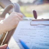 Examiner filling in driver's license road test form