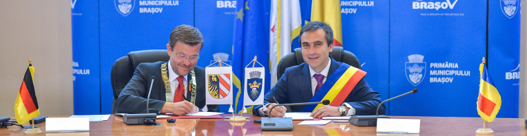 Oberbürgermeister Marcus König und sein Amtskollege  Allen Coliban unterzeichnen den Partnerschaftsvertrag zwischen Nürnberg und Braşov.