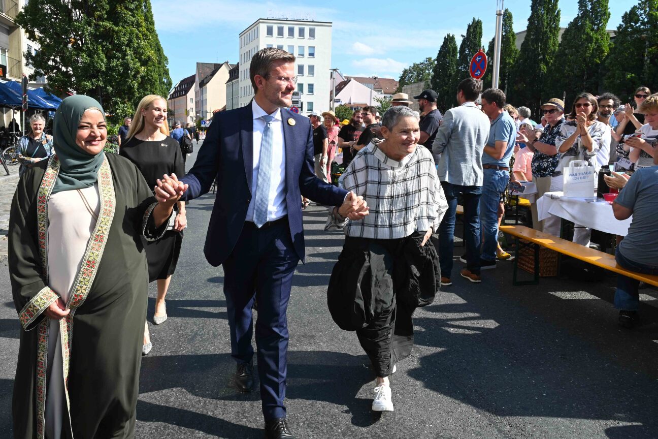 Die beiden Preisträgerinen des Nürnberg Menschenrechtspreises 2025, (v.links) Laila AlSheikh und Robi Damelin werden von Oberbürgermeister Markus König, nach der Friedenspresiverleihung am Sonntag, 21.September 2025, bei ihrem Gang über die Friedenstafel begleitet.