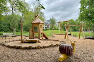 Bild Der neue Spielplatz an der Flußstraße ist am Montag, 6. Mai 2024, der Öffentlichkeit übergeben worden. Das Bild zeigt den Kleinkinderbereich mit Baumhaus und Seilbahn.