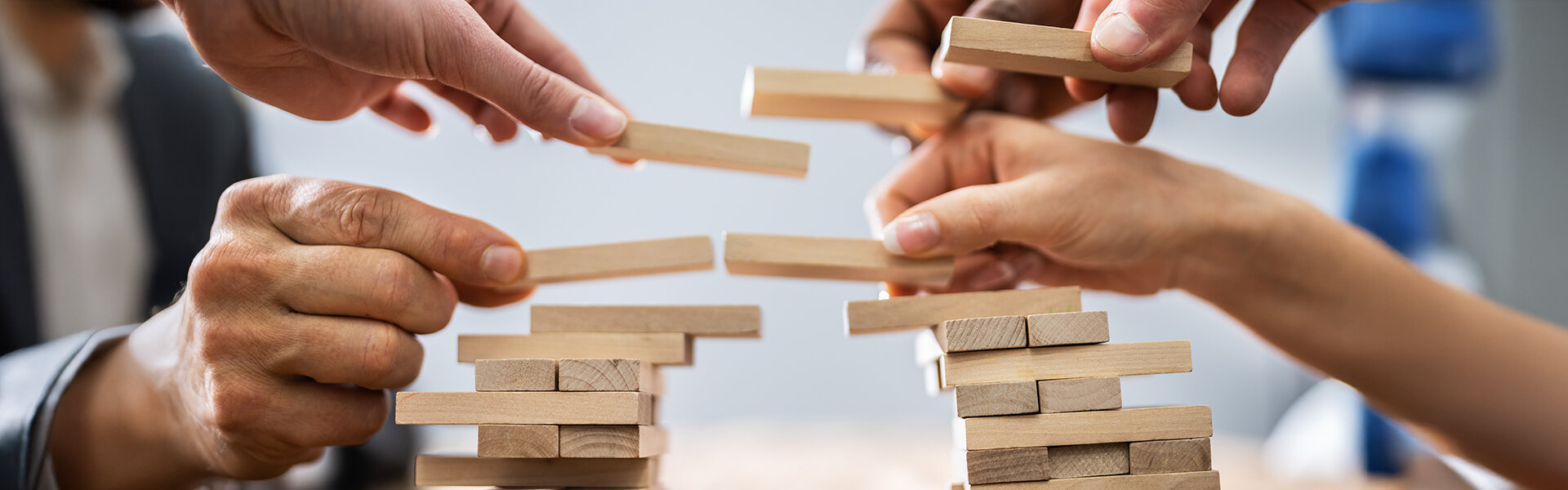 Hände bauen eine Holzbrücke