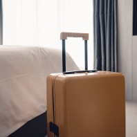 Ein Koffer steht neben einem Bett