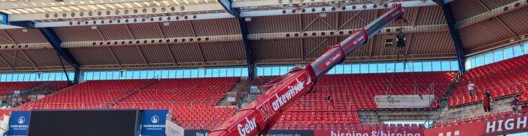 Ein Kranwagen hebt eine Tribünenplatte des Stadions an