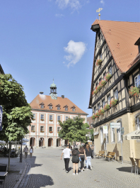 Das Bild zeigt das Rathaus (Mitte) und das Gebäude der Sparkasse (rechts) in Neustadt an der Aisch, zwei Bauwerke, die Fritz Mayer errichtet bzw. umgebaut hat. Foto Wolfgang Mück, 2022. (Privatbesitz)