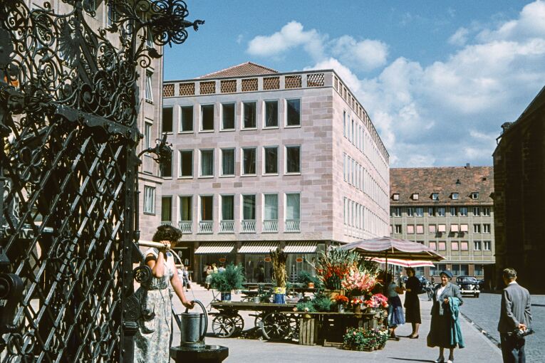 Das Gebäude am Hauptmarkt 16 wurde 1957/58 als modernes Büro- und Geschäftshaus errichtet. Die sandsteinverkleidete Fassade korrespondiert mit der sachlichen Architektur des Rathausneubaus. Foto Hochbauamt, um 1958. (StadtAN A 55 Nr. I-13-6-4)