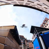 Blick von unten auf Mountainbiker im Flug über den Hauptmarkt.