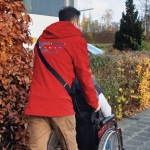 Ein Mann mit roter Jacke mit der Aufschrift Begleit-Dienst schie