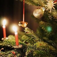 Brennende Wachskerzen am geschmückten Weihnachtsbaum