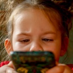 Kind schaut angestrengt auf das Smartphone
