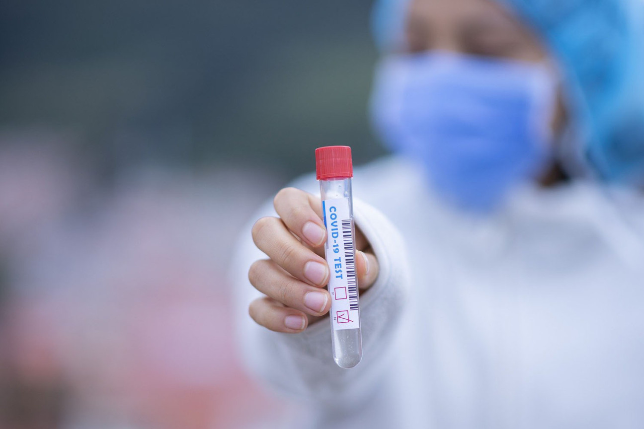 Bild © Bild: Pixabay Personal in Schutzkleidung hält ein Teströhrchen in die Kamera., Bild © Bild: Pixabay