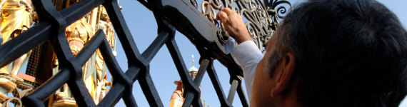 Tourist dreht am goldenen Ring am Schönen Brunnen